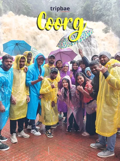 A vibrant group photo in colorful raincoats at a waterfall in Coorg. The monsoon brings out the best colors in nature and on our travelers.