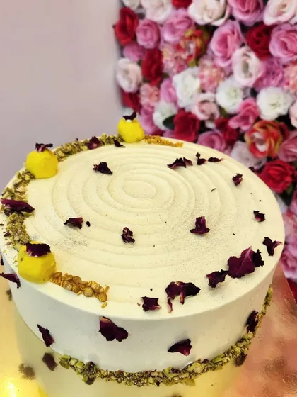 A fusion of two classic Indian sweets. My Rasmalai cake features a soft, moist sponge infused with rasmalai flavor, topped with delicate rose petals and pistachios. It's a unique dessert that's perfect for festive occasions.