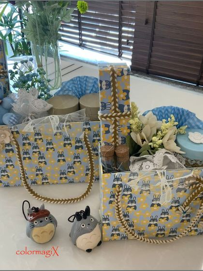 Another view of our blue-themed baby boy hampers. The image highlights the patterned gift totes with sturdy rope handles, filled with a mix of essentials and decorative items.