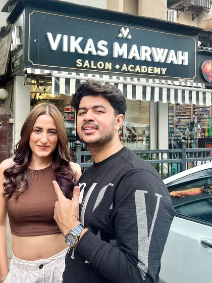 A happy client posing with me outside my Oshiwara salon. I don't just make bad hair disappear; I create good hair days that last.