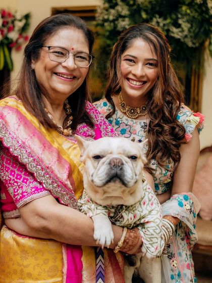 A joyful family photo, complete with their furry friend. It’s moments like these that make a wedding so special, and I love creating looks that make everyone feel their best.