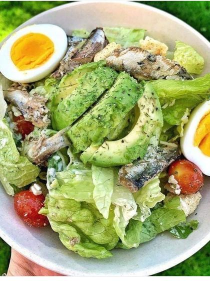 A nutritious and protein-packed salad. This dish combines fresh greens with avocado, hard-boiled eggs, cherry tomatoes, and sardines, all tossed in a light and creamy dressing.
