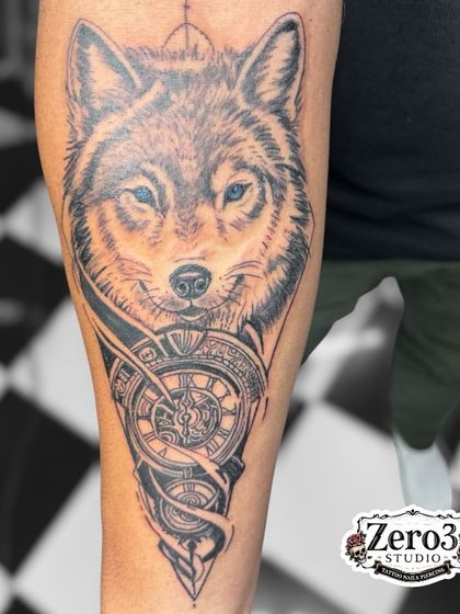 The healed wolf tattoo, showing how the design settles into the skin. The blue eyes add a striking focal point to the piece.