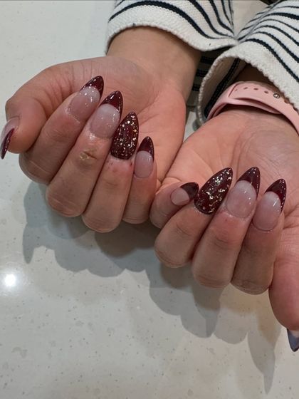 Another view of our maroon and glitter French design, showing how the light catches the sparkling accent nail.