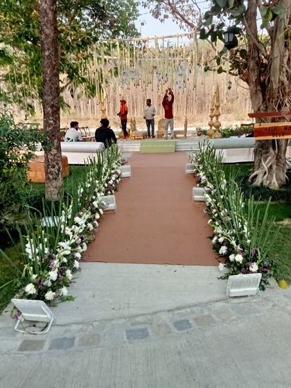 A simple yet beautiful walkway lined with white gladiolus flowers, leading guests to the main event area.