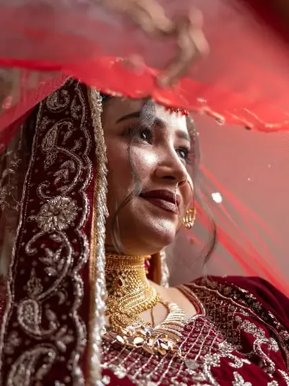 A dynamic shot of a bride with her red veil flowing, creating a sense of movement and grace.