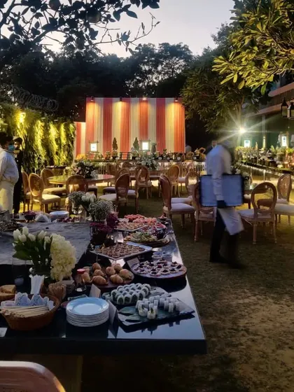 An evening view of one of our outdoor event setups, where the grazing table becomes a focal point for guests to gather and mingle under the lights.