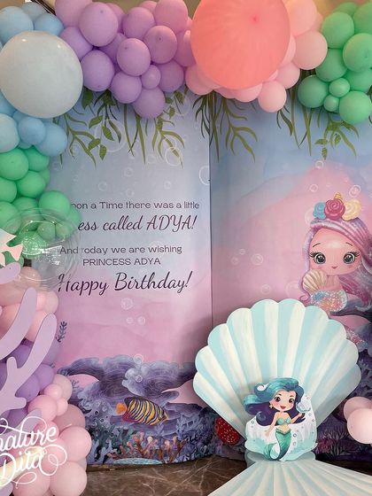 A close-up of the mermaid storybook backdrop, which reads 'Once upon a time there was a little princess called Adya'.