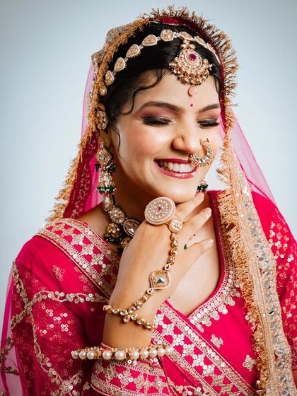A joyful close up highlighting the hathphool and the intricate design of the bridal bangles.
