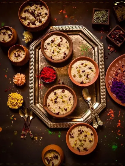 Indulge in our Splashy Rasmalai this Holi. This tray of creamy desserts, set against a backdrop of festive colors, is a treat for both the eyes and the palate.