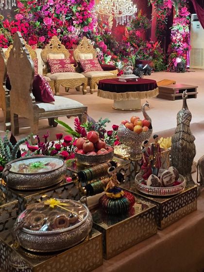 A close-up of the offering table from the red floral cave wedding, showing the silver peacock bowls and fresh fruits.