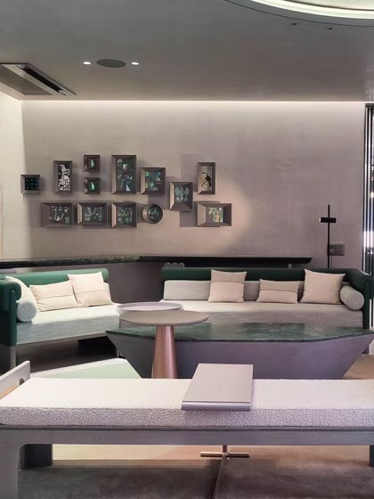 A wide view of the commercial space featuring the collection of framed abstract paintings, showing how they are integrated into the interior design.