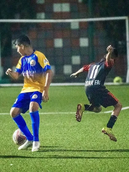 A player from our U13 team controls the ball under pressure from a defender in the semi-final.