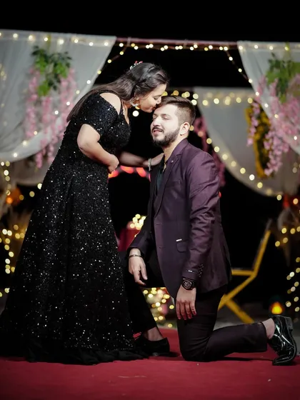 A classic proposal pose during a pre-wedding shoot, made magical with a backdrop of fairy lights.