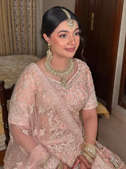 A seated portrait of my Walima bride. The soft peach tones of her makeup create a harmonious and elegant look that is both regal and modern.