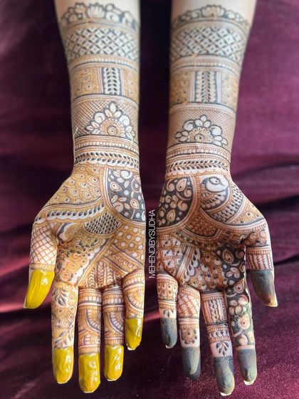 A top-down view that captures the full detail of the peacock and floral patterns on the palms and arms.