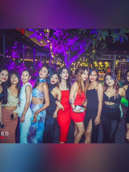 A group of friends dressed to impress and enjoying the night at my poolside party. It's all about good music and great company.