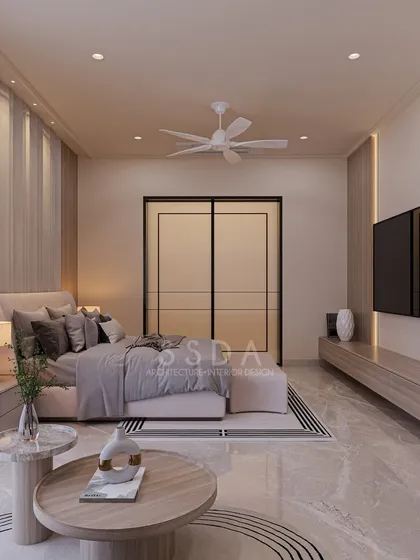 Another angle of the farmhouse master bedroom, showing the layout with a small seating area and nesting coffee tables. The design feels modern, timeless, and balanced.