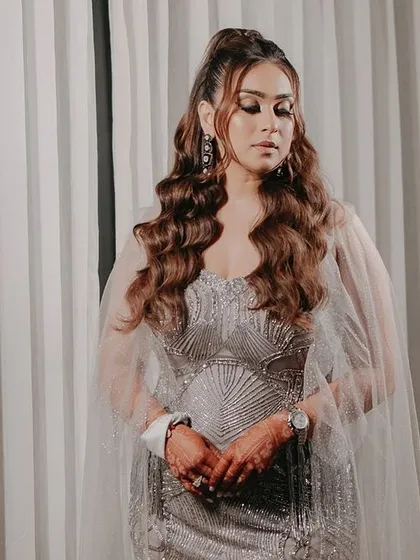 A stunning portrait of the bride in her glamorous silver gown. The soft, even lighting and simple background let her natural beauty and elegant attire shine.