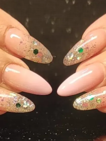 A delicate and feminine design with sheer pink nails and accent nails covered in holographic glitter.