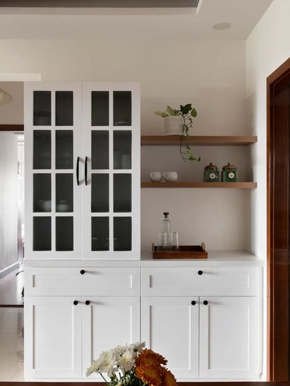 This crockery unit has a distinct English vibe, with glass-fronted upper cabinets and closed storage below. Open ledges provide a space to display plants and decor.