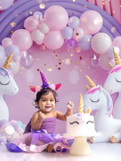 A magical unicorn-themed cake smash. This setup with pastel balloons, fluffy clouds, and adorable unicorns is perfect for a dreamy first birthday.