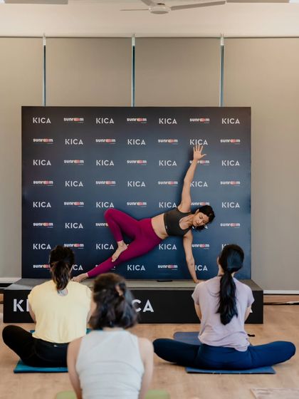 Demonstrating a variation of Side Plank (Vasisthasana) on stage during a yoga event. This pose is a great way to build core and arm strength.