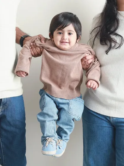 A fun and playful shot with the baby suspended between mom and dad. It’s a creative take on the family portrait that shows their lighthearted connection.
