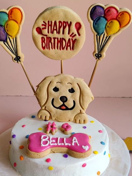 A close-up of Bella's 9th birthday cake. It features our signature polka-dot design, a cookie portrait, and balloon toppers for a festive touch.