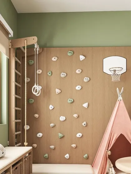A close-up of the play wall in the kids' room. It features a climbing ladder, a rock-climbing section, and a mini basketball hoop, providing endless opportunities for active and imaginative play.