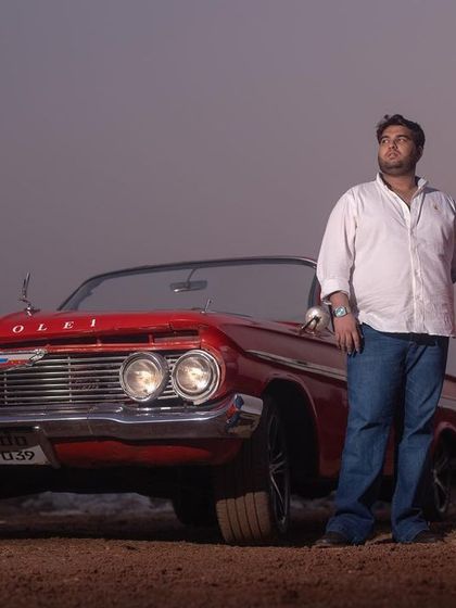 A full shot of the couple with a classic Chevrolet, showcasing the car as a stunning prop for a themed pre-wedding shoot.