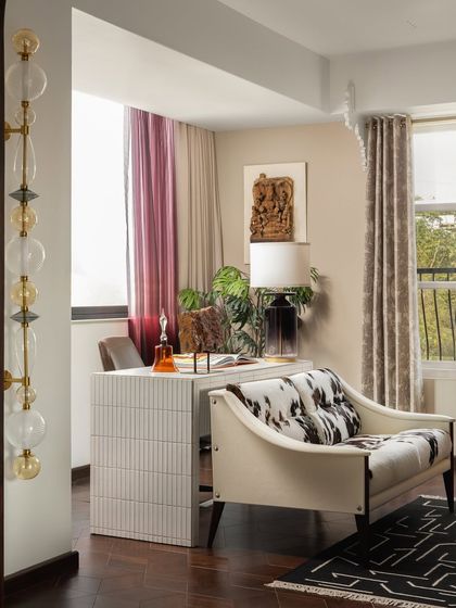 My favorite corner in this luxurious Mumbai apartment is this unique lounge and mini study. Sprinkled with statement art pieces and bathed in natural light, it's a serene sanctuary for work or relaxation.