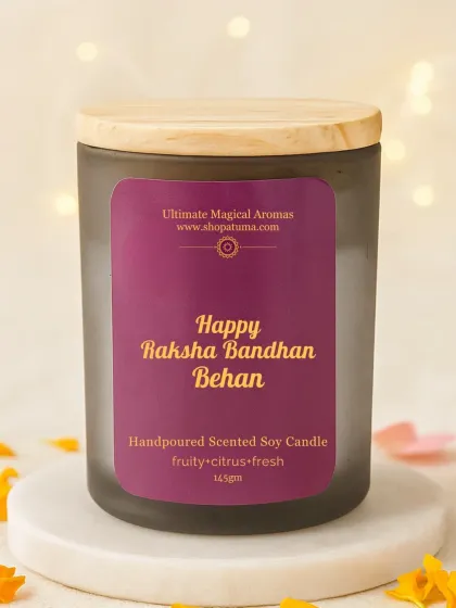 A close-up of the 'Happy Raksha Bandhan Behen' candle. This hand-poured soy wax candle comes in a fruity, citrus-fresh fragrance, housed in a beautiful frosted jar with a wooden lid.