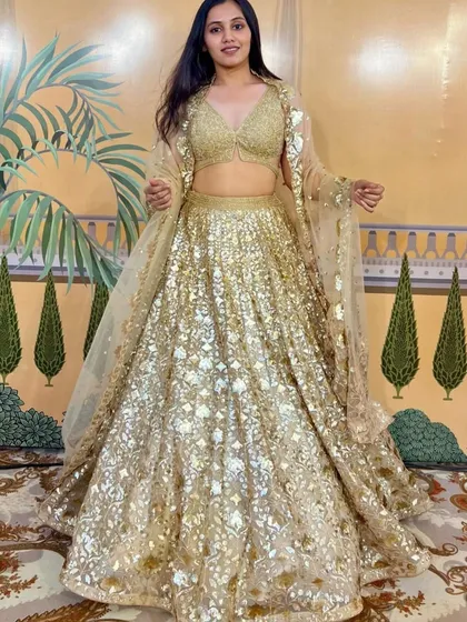 Shine bright with our collection of all-gold and sequined lehengas. This stunning piece is perfect for a glamorous sangeet or reception, designed to catch every light and make you the center of attention.