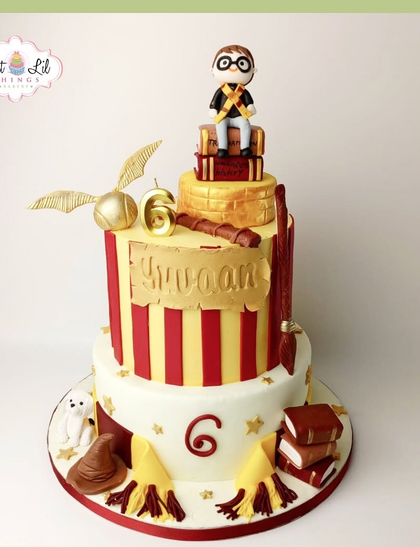A magical two-tiered Harry Potter cake for a 6th birthday. This Gryffindor-themed cake features a fondant Harry, the Sorting Hat, and the Golden Snitch.
