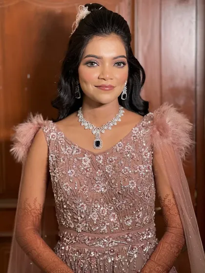 A portrait of the bride in her beautiful gown with feather-detailed shoulders.