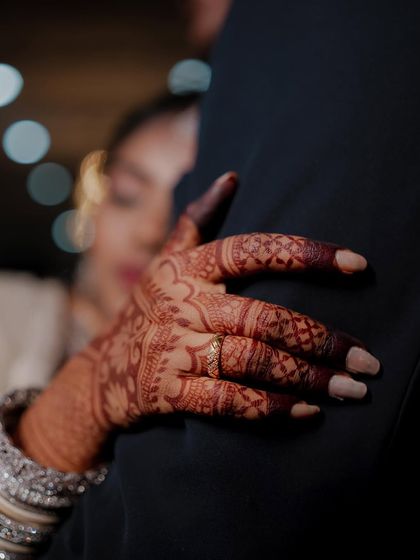A candid, artistic shot showing the bride's hand with its rich henna stain, a symbol of her new journey.