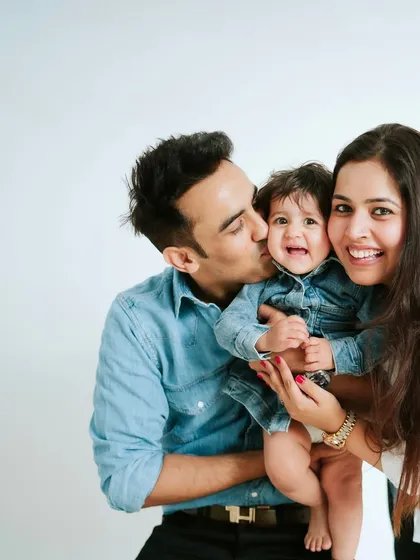 A sweet kiss for the little one. These moments of affection are what make family photos so precious.