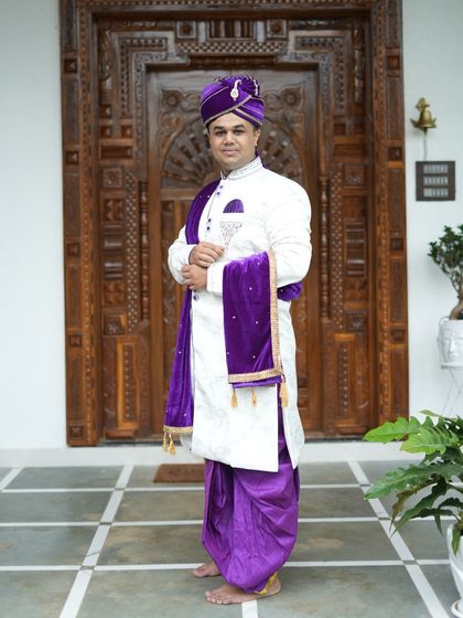 The complete royal look for a groom. This white sherwani with purple accents is one of our most requested rental pieces for traditional Maharashtrian weddings.