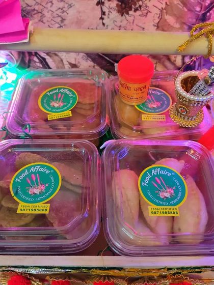 A close-up of the four-section tray inside the Holi hamper, neatly packed with Gujiya, Kachori, and two types of Mathri.