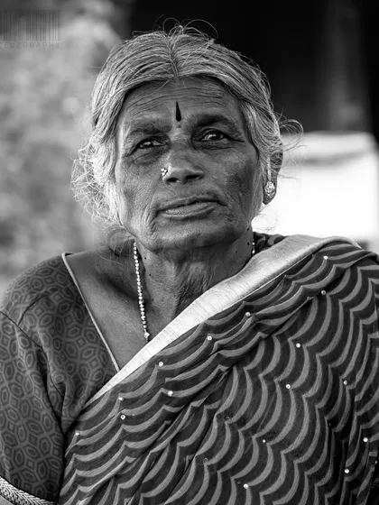 Black and white photography strips away distractions and reveals the soul. This portrait of a woman on the street uses monochrome tones to emphasize her expression and the wisdom in her eyes, creating a timeless and powerful image.