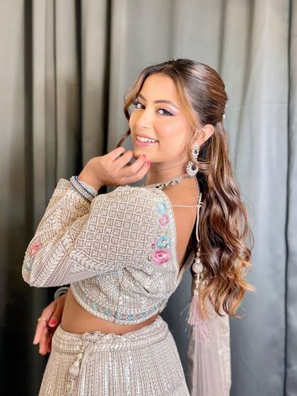 A smiling model showing the back of the pastel floral blouse, a unique design detail.