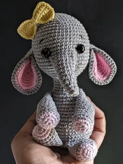 This sweet grey elephant plushie fits right in the palm of your hand. I added a little yellow bow and pink details inside the ears to give her a gentle character.