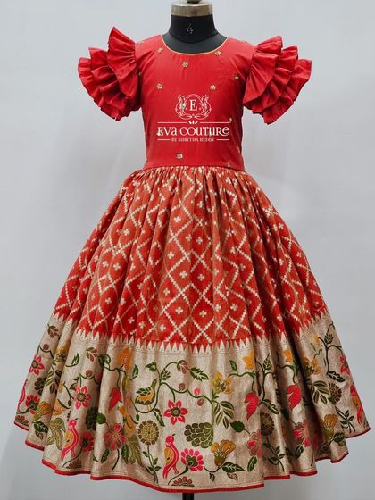 A beautiful red lehenga with a Paithani-style floral border. The blouse has modern ruffled sleeves.