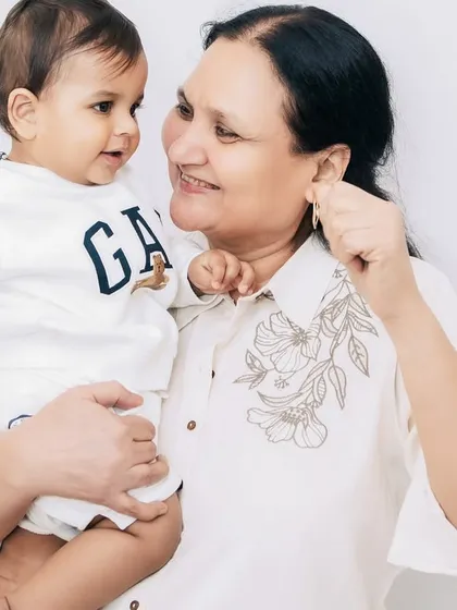 A first birthday is a family affair, and capturing the bond between a baby and his grandmother is truly special. Her loving gaze says everything about the pride and joy of being a grandparent.