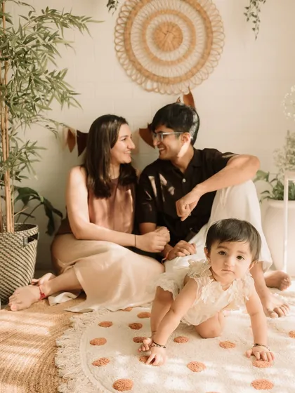 A candid moment of the parents looking at each other while their little one is ready to explore.