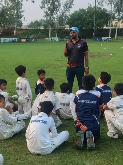 Another group of young players engaged in a discussion with their coach. We believe in building a strong team spirit and a sense of community.