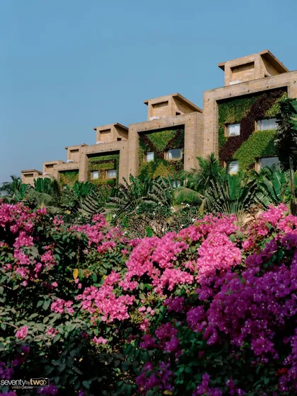 The stunning architecture of Della Resorts in Lonavala, with its vertical gardens and vibrant bougainvillea, providing a lush backdrop for a Mehendi ceremony.