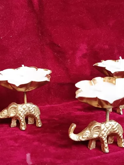 Another view of the elephant urli candles, showcasing the white wax against the golden elephant base.