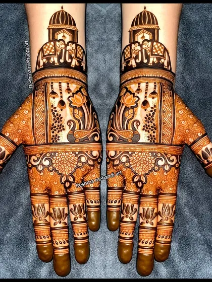 A perfect example of symmetrical bridal mehandi. Both hands mirror each other with designs featuring royal elephants, delicate lotus motifs, and hanging jhumkas, creating a balanced and classic look.